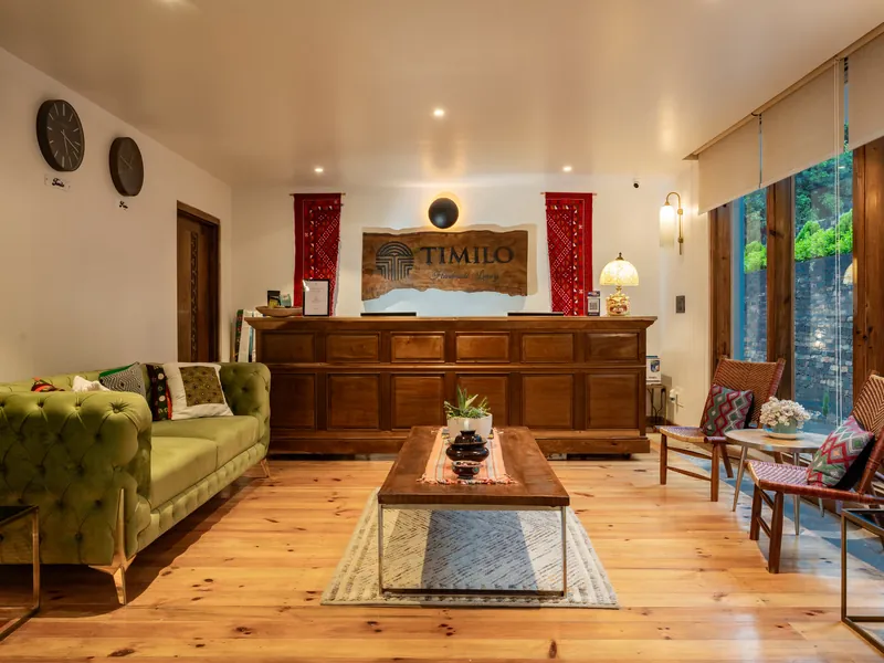 Reception with the hand-carved Timilo desk and a green velvet sofa