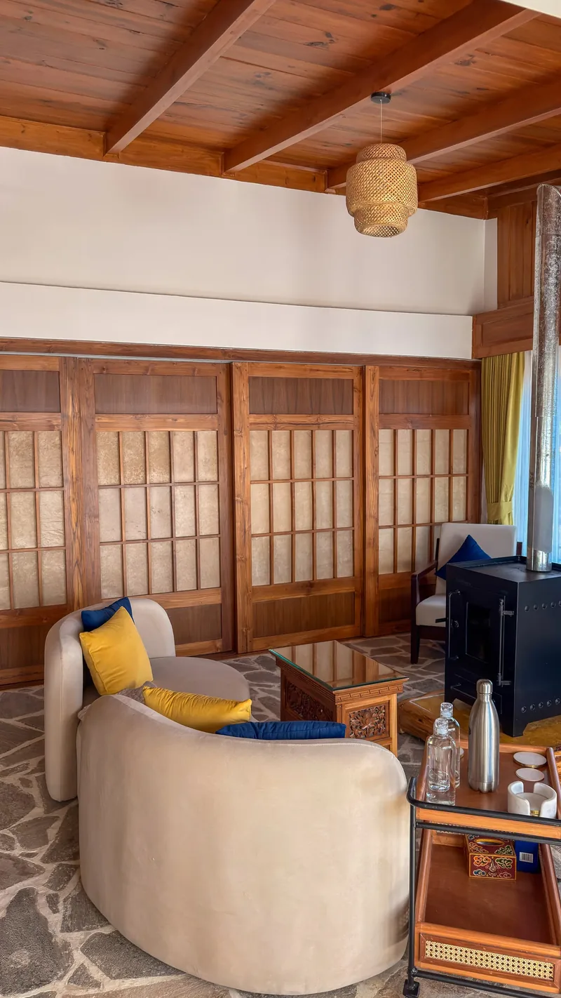 The suite's own sitting room, wood-slat doors drawn beside the stove — Presidential Suite, Timilo Boutique