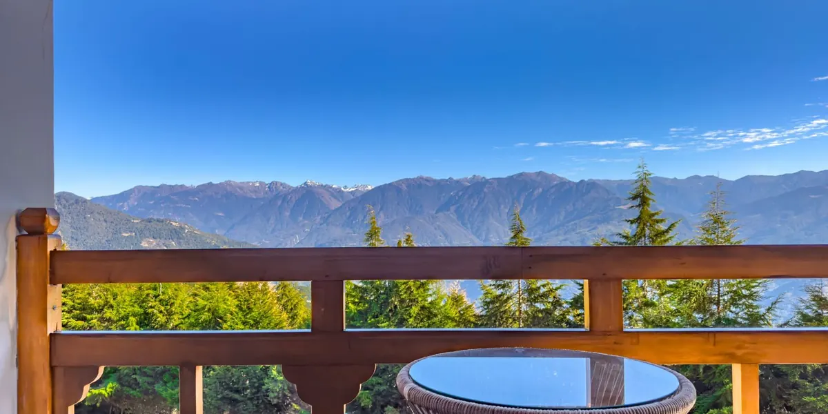 The private balcony of the Royal Double, a table for two set against the Tawang valley